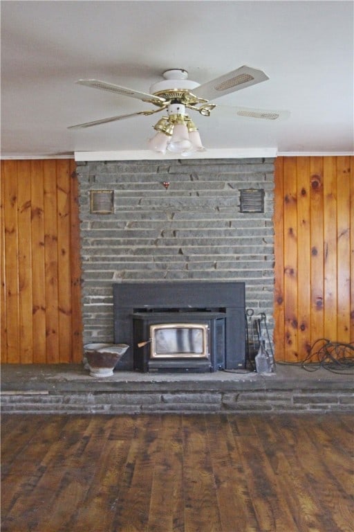 details featuring a fireplace, wood walls, hardwood / wood-style floors, and ceiling fan