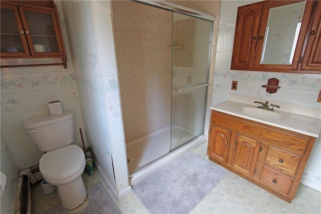 full bathroom featuring vanity, toilet, and a shower stall