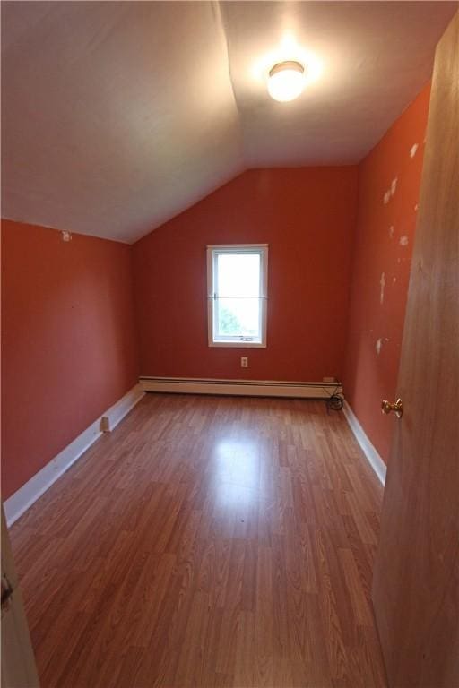 bonus room featuring baseboards, lofted ceiling, wood finished floors, and a baseboard heating unit