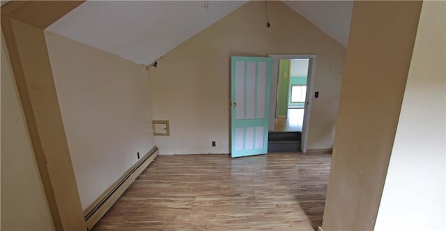interior space featuring a baseboard radiator, lofted ceiling, and wood finished floors