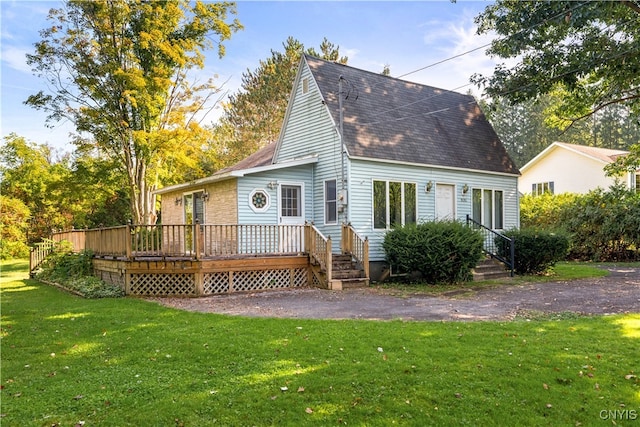 rear view of house featuring a lawn and a wooden deck