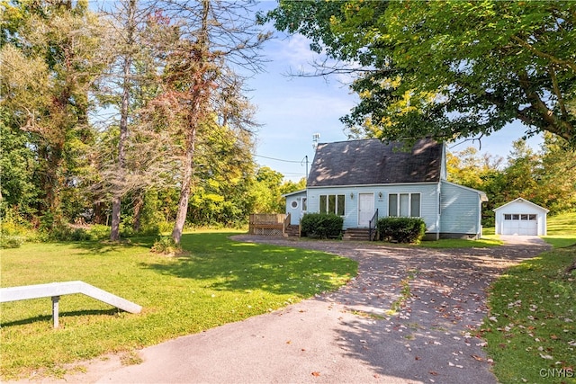 cape cod home with an outdoor structure, a garage, and a front yard