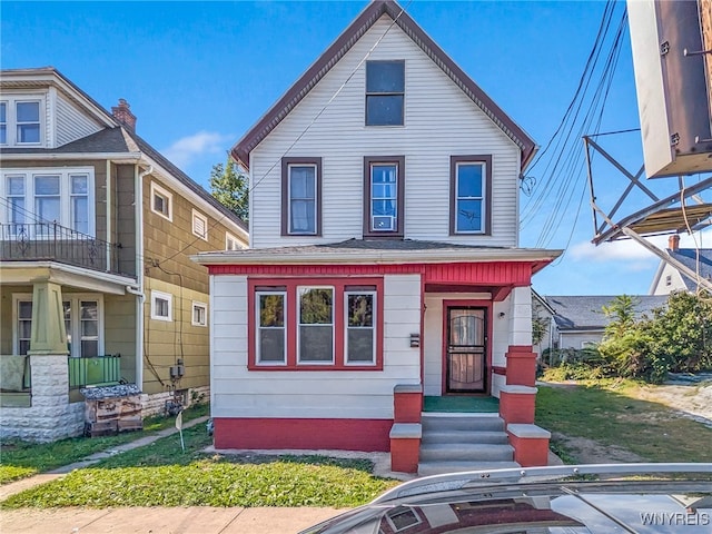 view of front of property with a balcony and a front yard