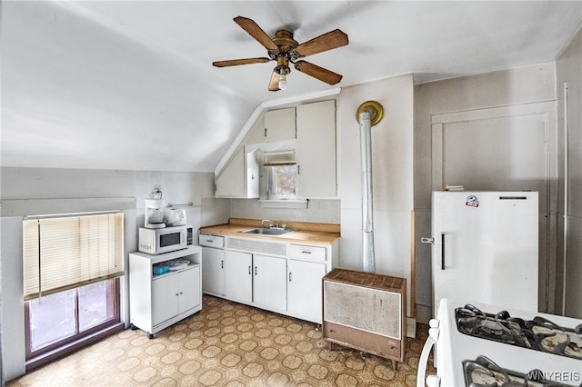 kitchen featuring sink, lofted ceiling, white appliances, decorative light fixtures, and ceiling fan