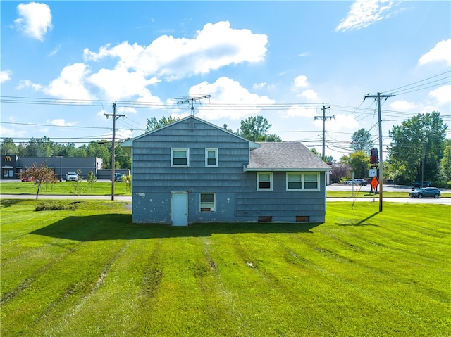 rear view of house featuring a lawn