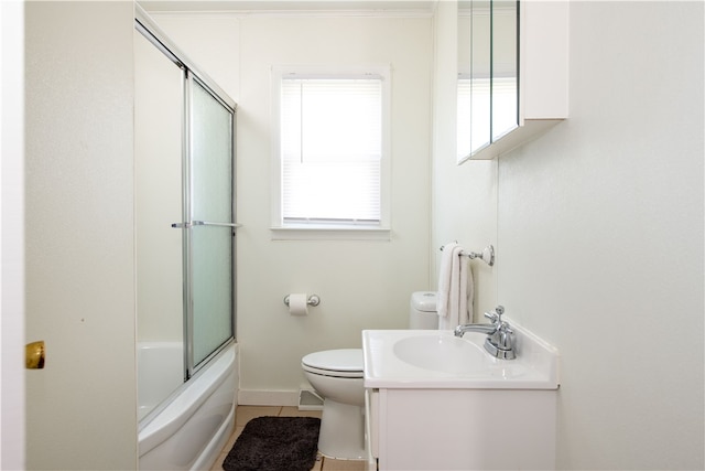 full bathroom featuring tile patterned floors, shower / bath combination with glass door, vanity, and toilet