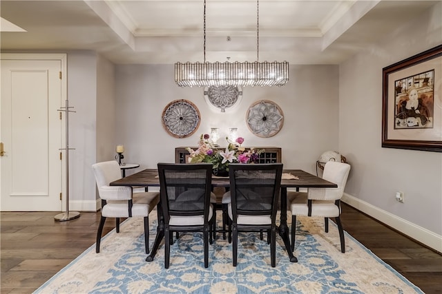 dining room featuring a notable chandelier, a raised ceiling, crown molding, and hardwood / wood-style flooring