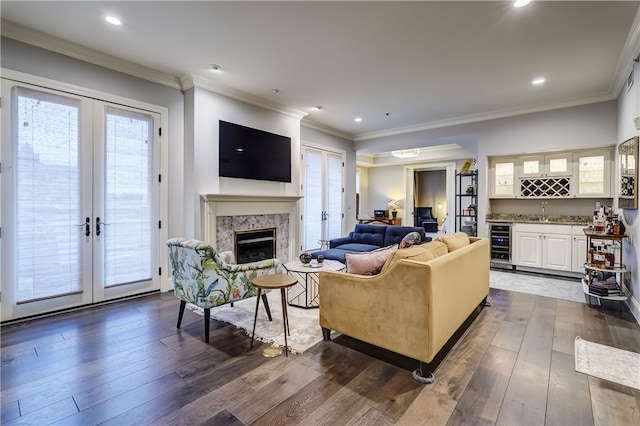 living room featuring wet bar, dark hardwood / wood-style floors, a premium fireplace, and french doors