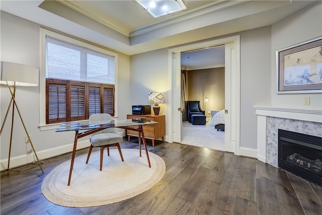 office featuring dark hardwood / wood-style flooring, a tray ceiling, and crown molding