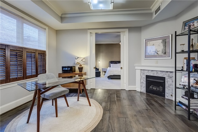 office area featuring ornamental molding, a tray ceiling, and dark wood-type flooring