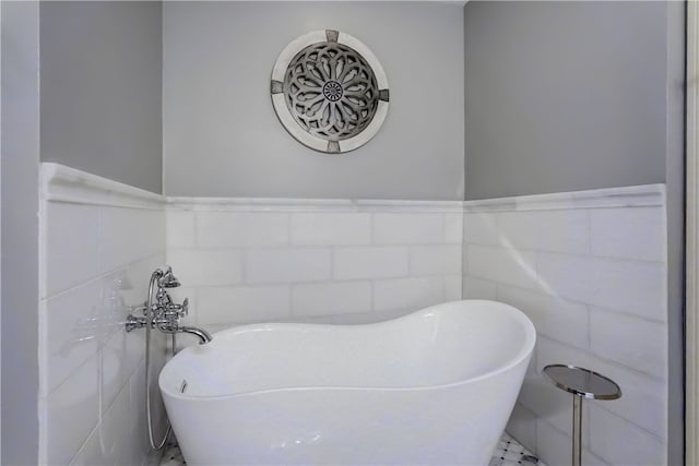 bathroom featuring a bathtub and tile walls