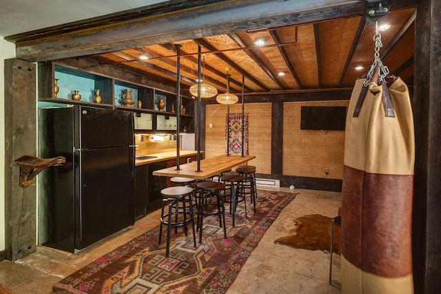 interior space featuring black fridge and hanging light fixtures