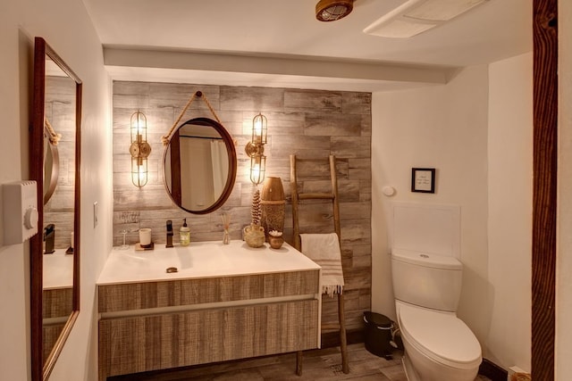 bathroom with tile walls, vanity, and toilet