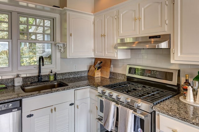 kitchen featuring appliances with stainless steel finishes, a healthy amount of sunlight, sink, and white cabinets