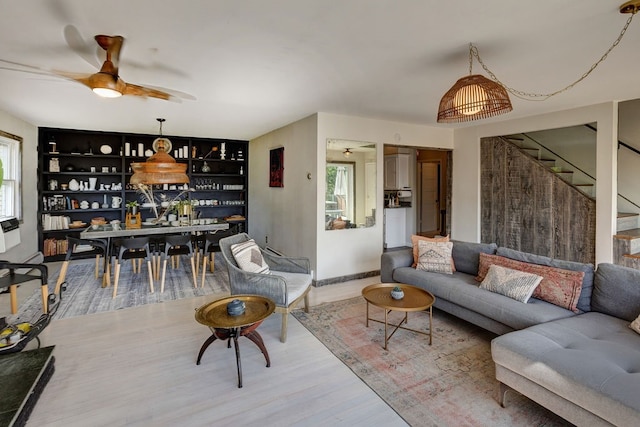 living room with ceiling fan, built in features, and hardwood / wood-style flooring