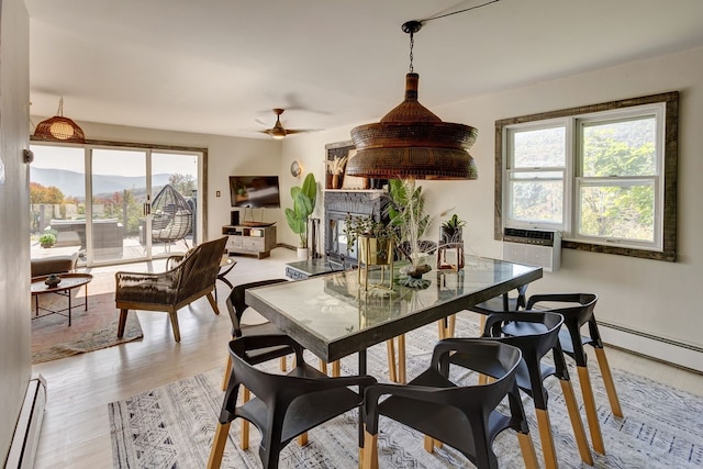 dining room featuring ceiling fan, cooling unit, a baseboard radiator, and light hardwood / wood-style floors