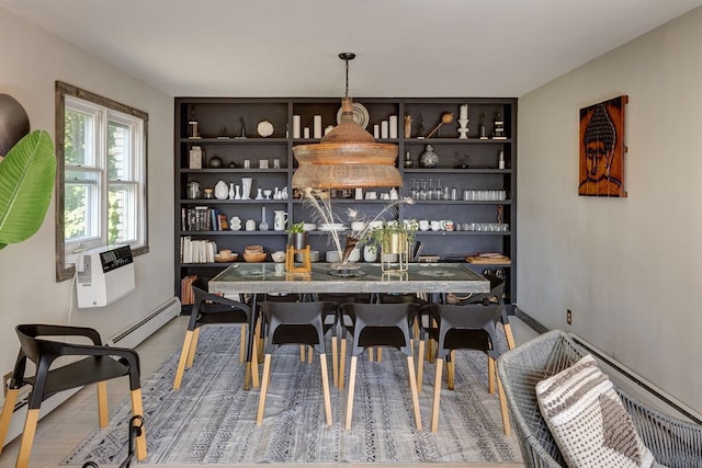 dining area with wood-type flooring and a baseboard heating unit