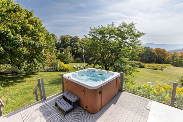 wooden deck with a lawn and a hot tub