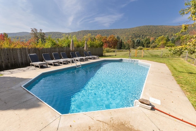 view of pool featuring a mountain view, a yard, and a patio area