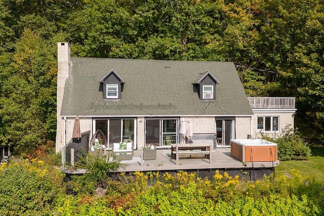 back of property with outdoor lounge area and a hot tub