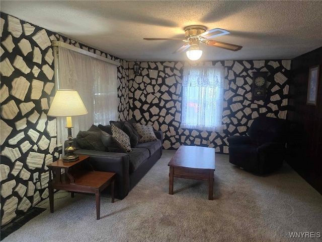 living room with ceiling fan, carpet floors, and a textured ceiling