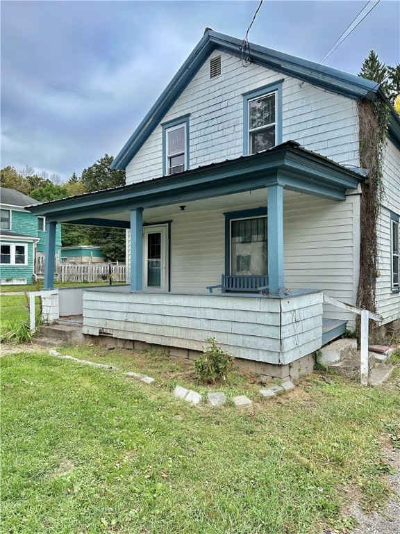 rear view of house with a lawn and covered porch