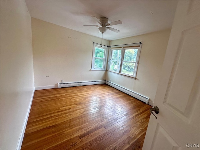 spare room with ceiling fan, a baseboard radiator, and wood-type flooring