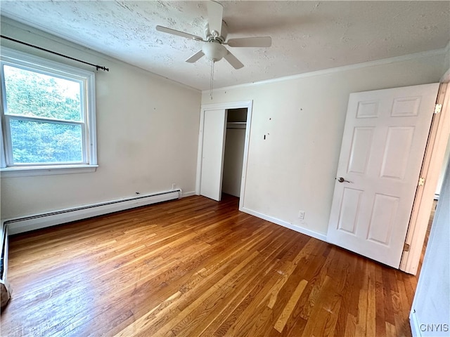 unfurnished bedroom with a closet, ceiling fan, hardwood / wood-style floors, and a textured ceiling