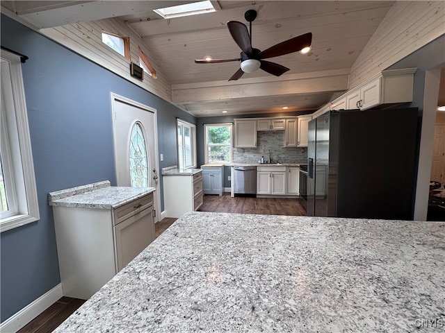 kitchen with appliances with stainless steel finishes, wood ceiling, dark hardwood / wood-style flooring, vaulted ceiling with skylight, and ceiling fan