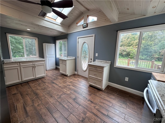 kitchen featuring ceiling fan, stove, vaulted ceiling with skylight, dark hardwood / wood-style floors, and wooden ceiling