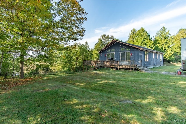 back of house with a lawn and a deck