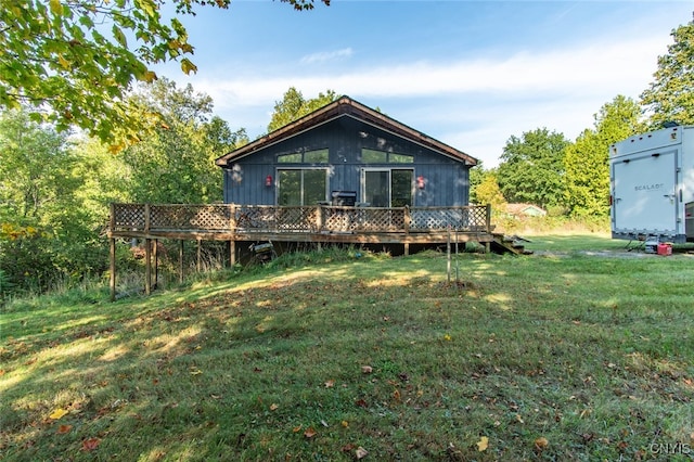 rear view of property with a yard and a wooden deck