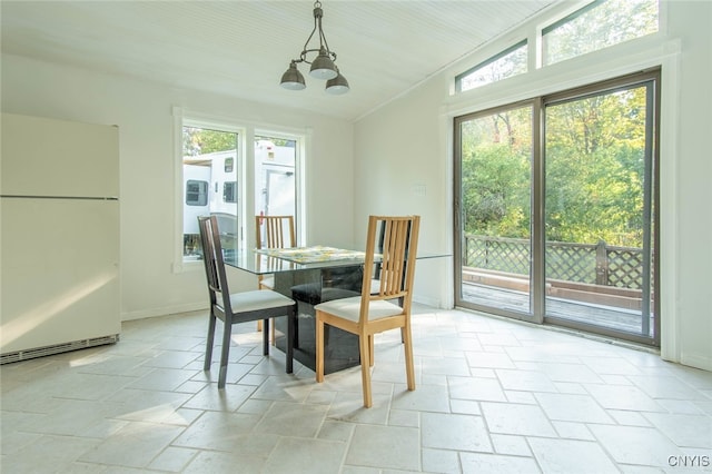 dining area with a notable chandelier and lofted ceiling