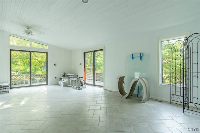 unfurnished living room featuring ceiling fan, vaulted ceiling, and a healthy amount of sunlight