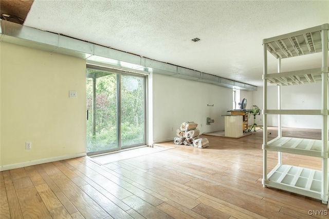 empty room featuring a textured ceiling and light wood-type flooring