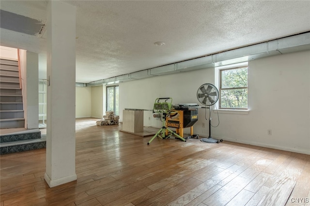 basement featuring a textured ceiling and light hardwood / wood-style flooring