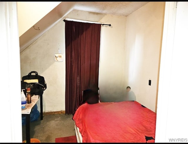 carpeted bedroom with a textured ceiling and lofted ceiling