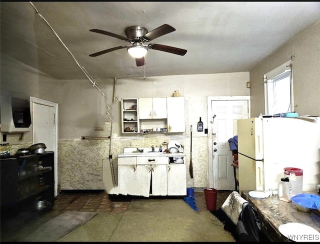 kitchen with white cabinetry, ceiling fan, and white fridge