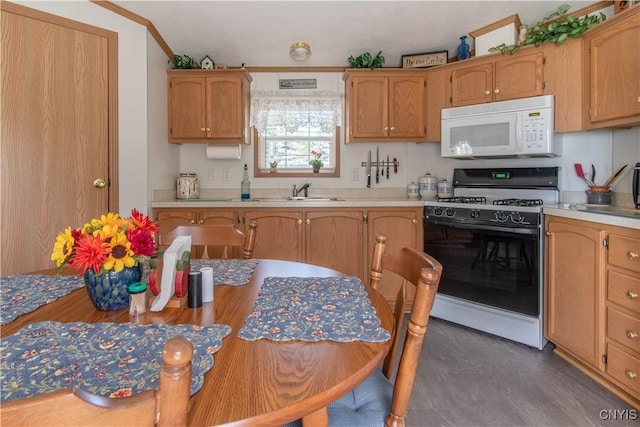 kitchen with gas range, a sink, white microwave, and light countertops