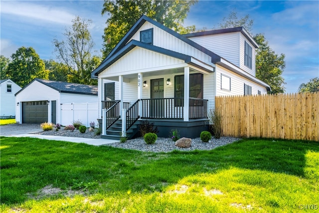 view of front of property with a front lawn, a porch, a garage, and an outdoor structure