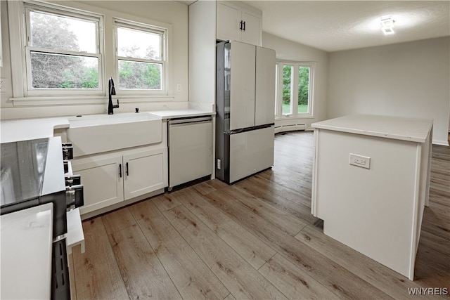 kitchen with a wealth of natural light, white cabinetry, appliances with stainless steel finishes, and sink