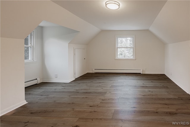 additional living space with lofted ceiling, baseboard heating, and dark hardwood / wood-style floors