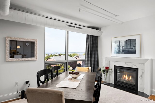 dining area with rail lighting, a fireplace, and wood-type flooring