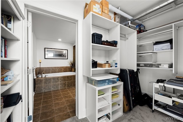 spacious closet featuring dark tile patterned floors