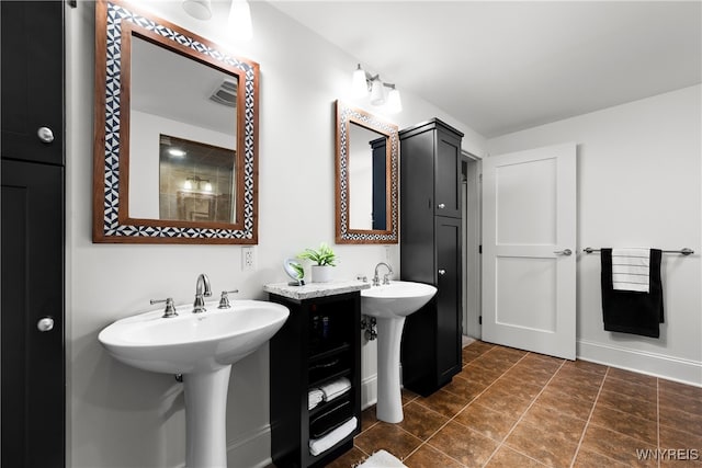 bathroom with dual sinks and tile patterned floors