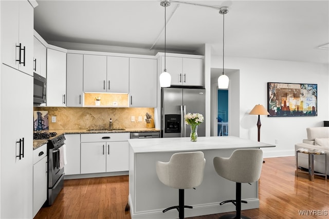 kitchen featuring decorative light fixtures, appliances with stainless steel finishes, and white cabinets