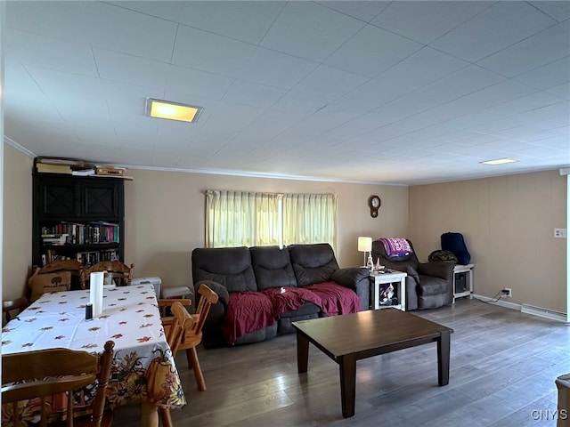 living room featuring a baseboard heating unit, hardwood / wood-style flooring, and crown molding