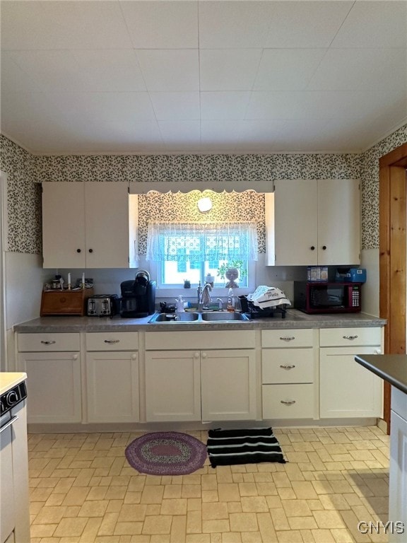 kitchen featuring white cabinets and sink