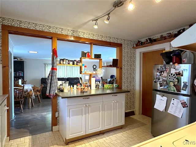 kitchen featuring stainless steel refrigerator, light hardwood / wood-style flooring, crown molding, and white cabinetry