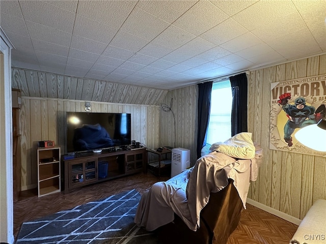 living room with wood walls and dark parquet floors